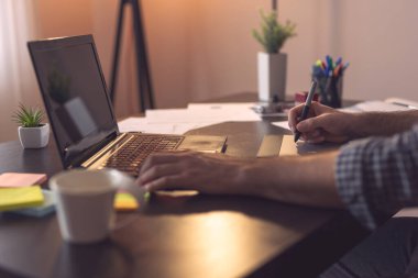 Erkek ellerinin çizim tahtası kullanarak çizimlerinin ayrıntıları. Kalemin ucuna ve parmaklarına odaklan.