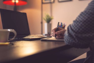 Erkek ellerinin çizim tahtası kullanarak çizimlerinin ayrıntıları. Kalemin ucuna ve parmaklarına odaklan.