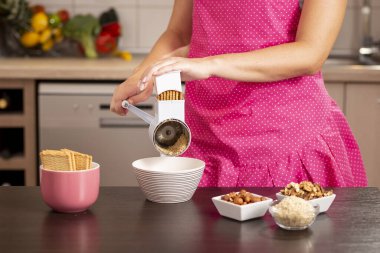 Pasta hazırlamak için bisküvi öğütücüsü kullanan bir kadın elinin ayrıntıları..