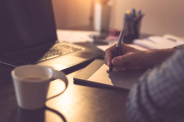 Erkek ellerinin çizim tahtası kullanarak çizimlerinin ayrıntıları. Kalemin ucuna ve parmaklarına odaklan.