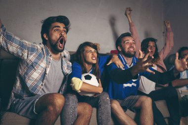 Bir grup genç arkadaş, bir binanın çatısında futbol maçı izleyip takımlarının gol atmasını kutluyorlar.