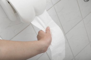 Tuvalet kağıdı kullanan bir kadının eli.