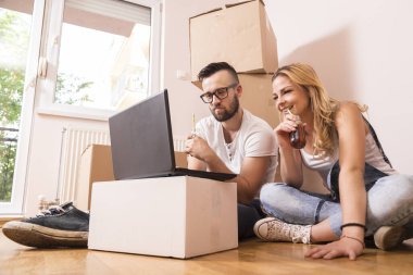 Birbirine aşık genç bir çift yeni evlerinin zemininde oturuyor ve yeniden dekore etmeyi planlıyor.