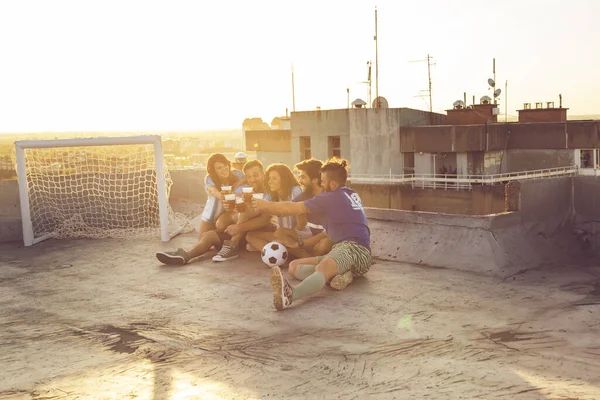 Группа Молодых Людей Сидит Крыше Здания Майках Отдыхает После Футбольного — стоковое фото