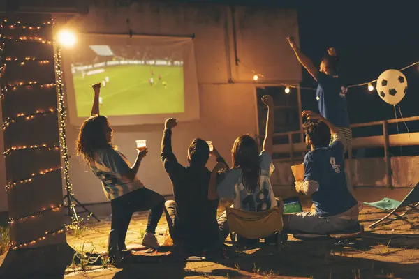 ビルの屋上でサッカーの試合を見たり ビールを飲んだり 応援したりする若い友人のグループ 中央の人々への選択的な焦点 — ストック写真