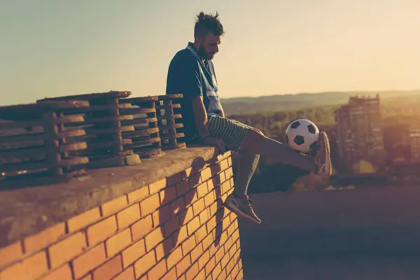 Bir Binanın Çatısındaki Futbolcu Maçtan Sonra Oturuyor Dinleniyor Elinde Bir — Stok fotoğraf