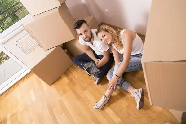 若いカップルは 新しいアパートに移動し 床に座って 新しい家を改装することを計画しています トップビュー — ストック写真