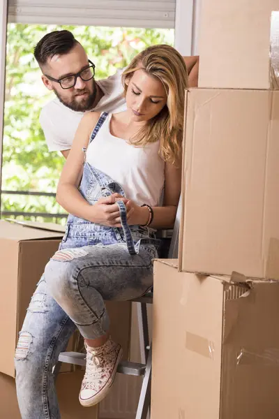 新しいアパートの段ボール箱の隣に立っている恋の若いカップル — ストック写真