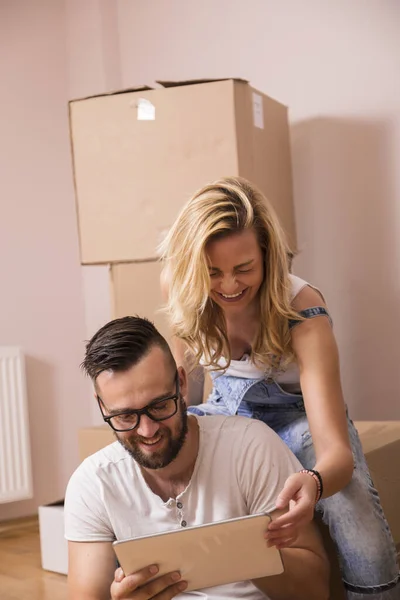 若いカップルの愛は 新しいアパートに移動します 床に座って 彼らの新しい家を飾るために計画 — ストック写真