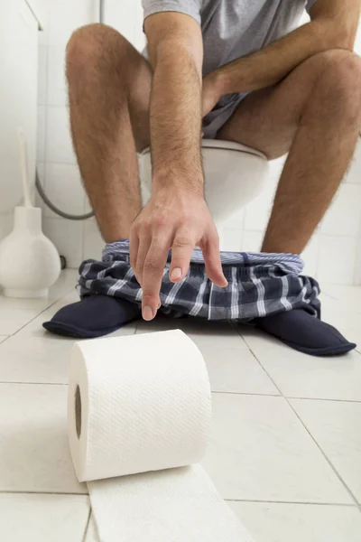 Szczegóły Człowieka Siedzącego Toalecie Sięgającego Papier Toaletowy — Zdjęcie stockowe