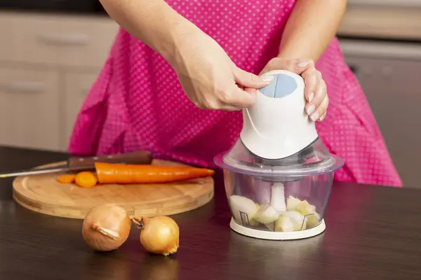 キッチンカウンターの玉ねぎチョッパーをオンにする女性の手の詳細 キッチンでランチを作る女性 玉ねぎを切る — ストック写真