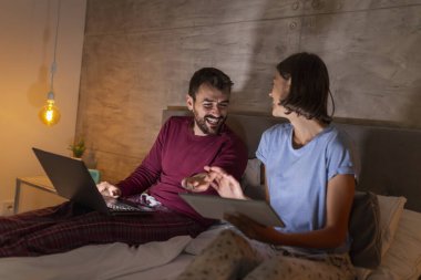 Güzel, genç bir çift gece yan yana yatar, seyahat yerleri arar, tatil planları yaparlar.