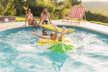 Havuz başında bir yaz partisinde aşık bir çift, güneşleniyor ve eğleniyor; kız ananas şeklinde bir şişme yatakta havuzda yüzüyor. 
