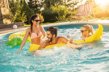 Havuz başında bir yaz partisinde bir grup arkadaş, yüzme havuzunda eğleniyorlar, su sıçratıyorlar ve yüzen bir yatak için kavga ediyorlar.