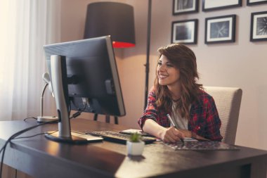 Ev ofisinde çalışan kadın grafik tasarımcısı, renk paletinden bir renk seçer