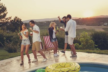 Bir grup arkadaş yaz havuz başında eğleniyor, dans ediyor ve bira içiyor.