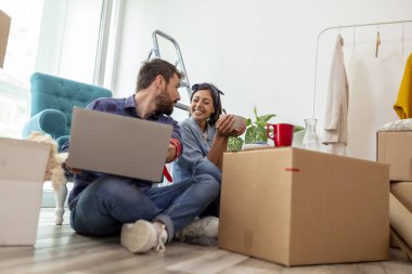 Güzel, birbirine aşık genç bir çift yeni dairelerinde karton kutuların arasında oturuyor, kahvaltı yapıyor ve dekorasyon fikirleri arıyor.