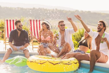 Havuz başında bir yaz partisinde bir grup arkadaş yüzme havuzunun kenarında oturuyor, bira içiyor, su sıçratıyor ve eğleniyorlar.