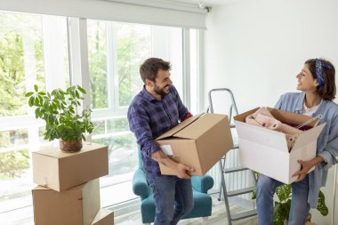 Birbirine aşık bir çift, karton kutuları taşırken ve yeni evi kurarken eğleniyor.