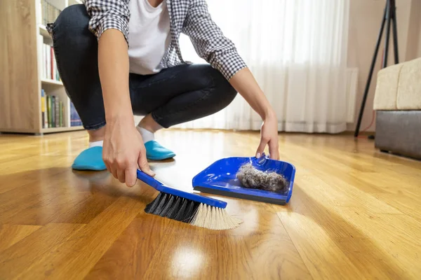 女性の手押しほうきとちりとりにほこりを集めて 床を掃除詳細 — ストック写真