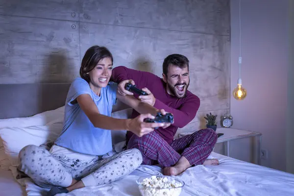 Красива Молода Пара Піжамах Розважається Вдома Грає Відеоігри Ліжку Вночі — стокове фото