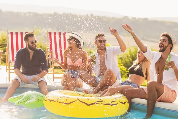 Havuz başında bir yaz partisinde bir grup arkadaş yüzme havuzunun kenarında oturuyor, bira içiyor, su sıçratıyor ve eğleniyorlar.