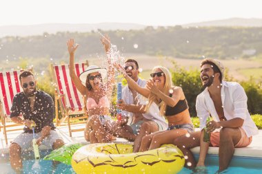 Havuz başında bir yaz partisinde bir grup arkadaş yüzme havuzunun kenarında oturuyor, bira içiyor, su sıçratıyor ve eğleniyorlar.