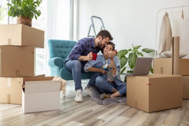 Birbirine aşık güzel genç bir çift birlikte yaşıyor, dizüstü bilgisayarla internette sörf yapıyor, internette daire dekorasyonu fikirleri arıyor. 