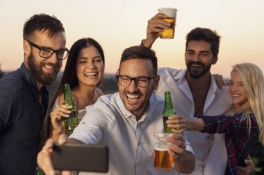 Bir grup arkadaş yaz partisinde eğleniyorlar, dans ediyorlar, bira içiyorlar ve selfie çekiyorlar.