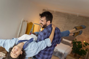 Güzel, yeni evli genç bir çift birlikte yaşamaya başlıyor. Karton kutuları eşyalarıyla boşaltıp eğleniyorlar. Erkek, kadını kollarında taşıyor.