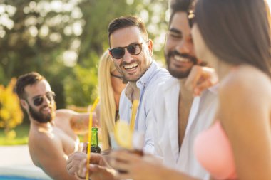 Havuz başında bir yaz partisinde bir grup arkadaş, yüzme havuzunun kenarında oturup, kokteyl ve bira içip eğleniyorlar.