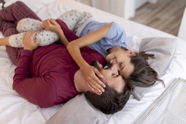 Aşık çift uyandıktan sonra yatakta yatıyor, sarılıyor, gülüyor ve birlikte vakit geçiriyorlar.