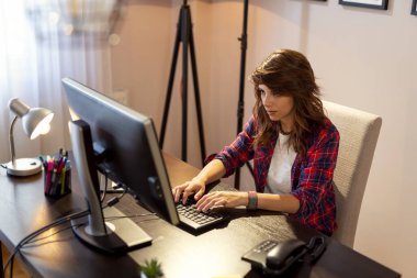 Evde çalışan genç bir programcı, klavyeye yazıp, kodluyor.