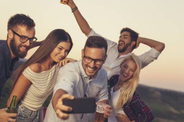 Bir grup arkadaş yaz partisinde eğleniyorlar, dans ediyorlar, bira içiyorlar ve selfie çekiyorlar.