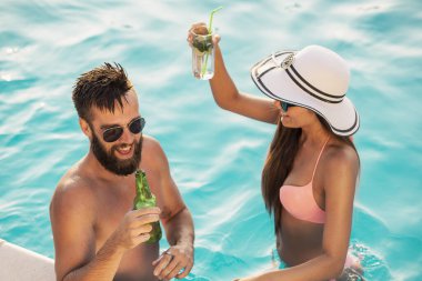 Havuz başında bir yaz partisinde aşık bir çift yüzme havuzunun kenarında duruyor, bira içiyor, dans ediyor ve eğleniyor.