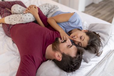 Aşık çift uyandıktan sonra yatakta yatıyor, sarılıyor, gülüyor ve birlikte vakit geçiriyorlar.