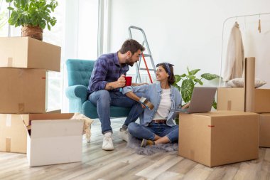 Birbirine aşık güzel genç bir çift birlikte yaşıyor, dizüstü bilgisayarla internette sörf yapıyor, internette daire dekorasyonu fikirleri arıyor. 