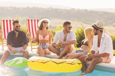 Havuz başında bir yaz partisinde bir grup arkadaş yüzme havuzunun kenarında oturuyor, bira içiyor ve eğleniyorlar.