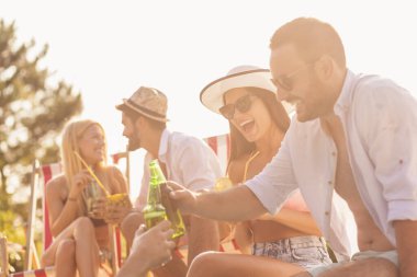 Havuz başında bir yaz partisinde bir grup arkadaş, yüzme havuzunun kenarında oturup, kokteyl ve bira içip eğleniyorlar.