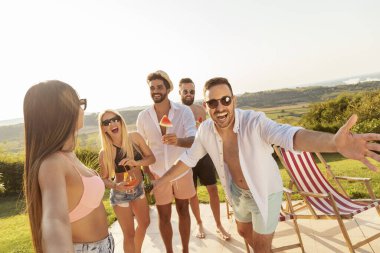 Bir grup genç arkadaş havuz başında bir yaz partisinde eğleniyor, bira içiyor ve onlara katılmaları için daha çok arkadaşını davet ediyor.