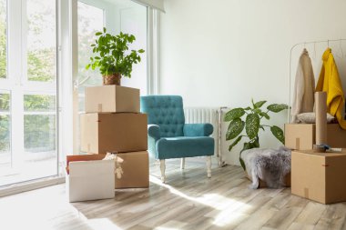 Bir demet karton kutu ve bir paket makinesiyle evin içini detaylandırmak; ailenin taşınması, taşınması veya ev konseptini yeniden dekore etmesi