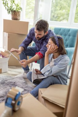 Birbirine aşık güzel genç bir çift yeni bir eve taşınıyor, tablet bilgisayar kullanıyor, internette iç tasarım fikirleri arıyor.