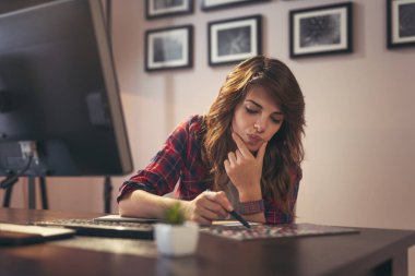 Ev ofisinde çalışan kadın grafik tasarımcısı, renk paletinden bir renk seçer