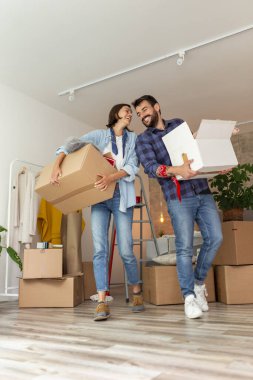Güzel, genç bir çift yeni bir daireye taşınırken eğleniyorlar, karton kutular taşıyorlar ve dairelerini dekore ediyorlar.