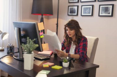 İş başarısından sonra elinde belgelerle gezen genç bir kadın, kutlama yapıyor.