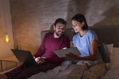 Güzel, genç bir çift gece yan yana yatar, seyahat yerleri arar, tatil planları yaparlar.