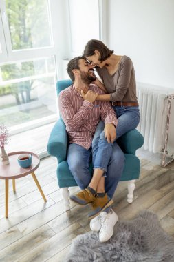 Birbirine aşık bir çift pencerenin kenarında oturuyor, sarılıyor ve birlikte eğleniyorlar.