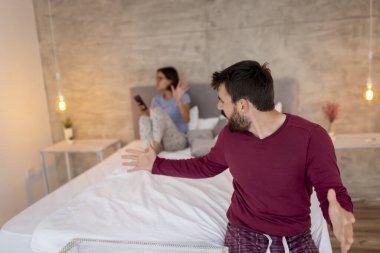 Yatak odasında tartışan, birbirine bağıran kızgın ve hoşnutsuz bir çift.