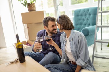 Güzel, genç ve aşık bir çift yeni evine taşınmayı kutluyor, bir kadeh şarapla kadeh kaldırıyor.