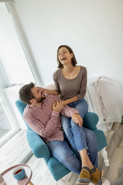 Birbirine aşık bir çift pencerenin kenarında oturuyor, sarılıyor ve birlikte eğleniyorlar.